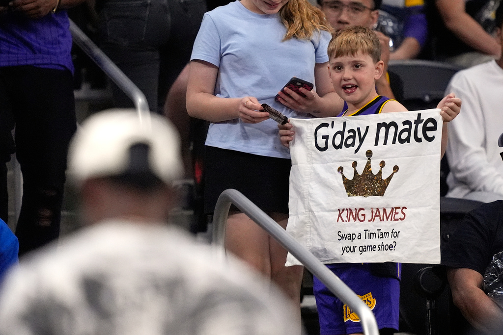A young fan holds up a sign for Los Angeles Lakers forward LeBron James, left, during the second half of an NBA preseason basketball game between the Lakers and the Phoenix Suns, Friday, Oct. 3, 2025, in Palm Desert, Calif. (AP Photo/Mark J. Terrill)