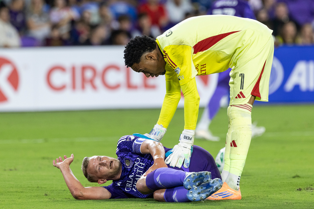 Orlando City goalkeeper Pedro Gallese (1) checks on injured Orlando City defender Robin Jansson, bottom, during the first half of an MLS soccer match against the Vancouver Whitecaps, Saturday, Oct. 11, 2025, in Orlando, Fla. (AP Photo/Kevin Kolczynski)