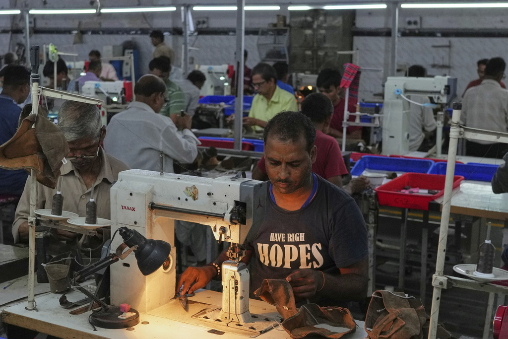A worker stitches a footwear in a manufacturing unit in Agra, India, Monday, Aug. 25, 2025. (AP Photo/Manish Swarup)
