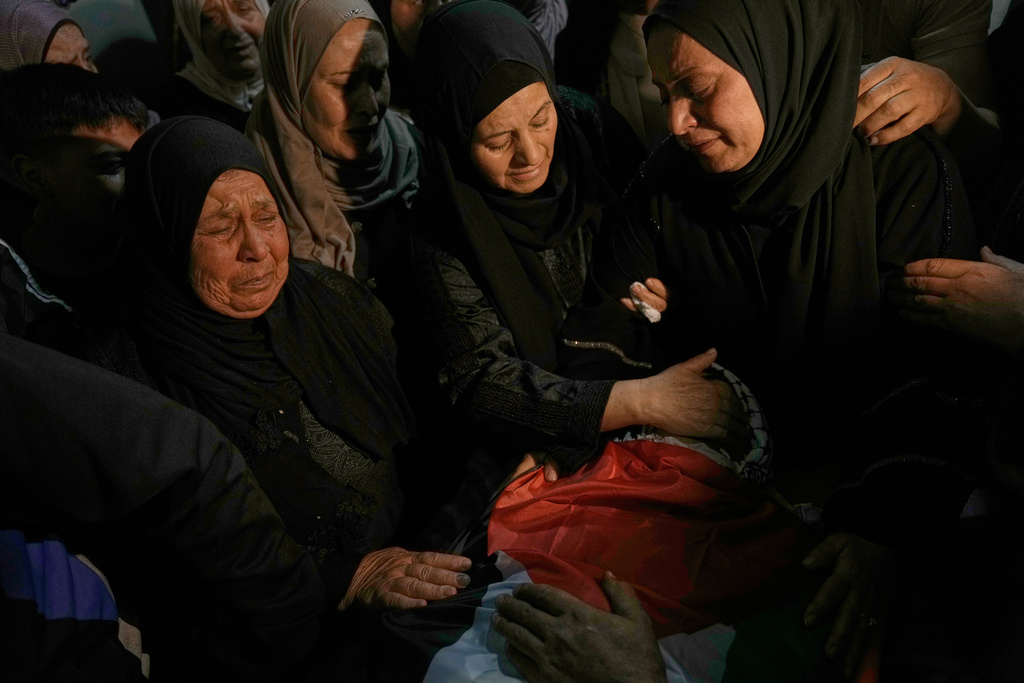 Palestinian women mourn over the body of Jamil Hanani, 17, who, according to health authorities, was killed after being shot in the chest during an Israeli raid, at his funeral in the West Bank village of Beit Furik, Monday, Nov. 3, 2025. (AP Photo/Majdi Mohammed)