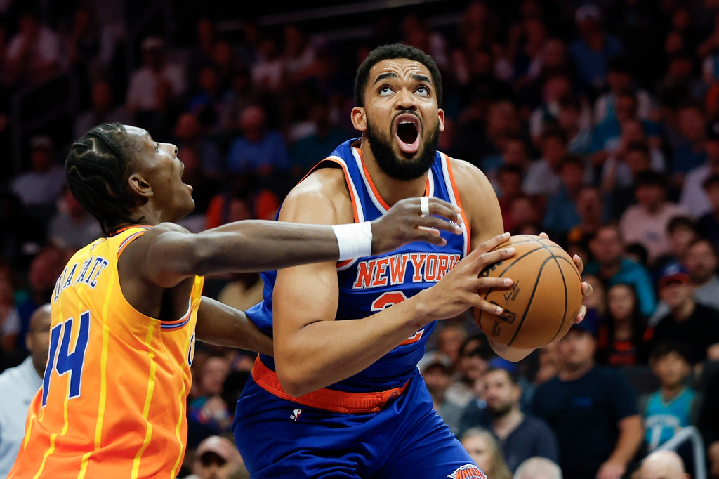 New York Knicks center Karl-Anthony Towns, right, prepares to shoot against Charlotte Hornets forward Moussa Diabate during the first half of an NBA basketball game in Charlotte, N.C., Thursday, March 26, 2026. (AP Photo/Nell Redmond)