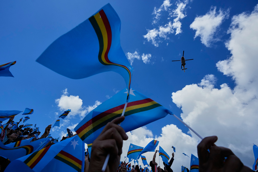 People wave the Naga flag as a chopper arrives carrying Thuingaleng Muivah, leader of the National Socialist Council of Nagaland (Isak-Muivah), in Ukhrul, in the northeastern Indian state of Manipur, Wednesday, Oct. 22, 2025. (AP Photo/Anupam Nath)
