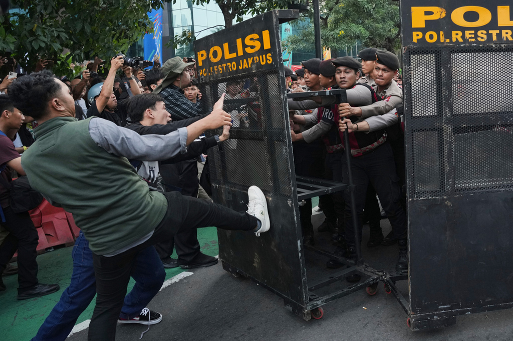 Police officers block student protesters during a rally against a fuel price hike, government inefficient spending, and military involvement in civilian affairs in Jakarta, Indonesia, Friday, June 12, 2026. (AP Photo/Tatan Syuflana)