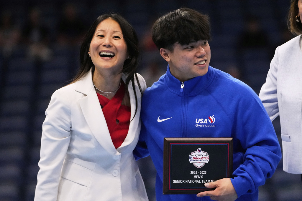 USA Gymnastics president Li Li Leung poses with overall winner Asher Hong of Stanford University after the senior men's finals of the U.S. Gymnastics Championships in New Orleans, Saturday, Aug. 9, 2025. (AP Photo/Gerald Herbert)