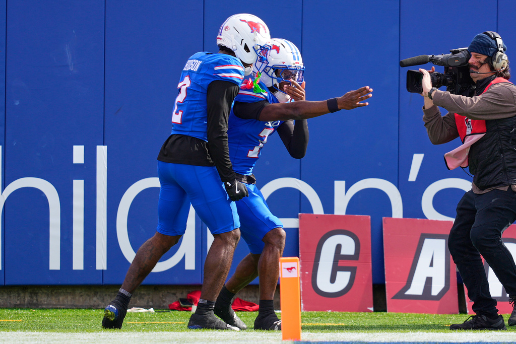 SMU wide receiver Jordan Hudson (2) and quarterback Kevin Jennings (7) celebrate after Jennings ran the ball for a touchdown in the first half of an NCAA college football game against Louisville Saturday, Nov. 22, 2025, in Dallas. (AP Photo/Tony Gutierrez)