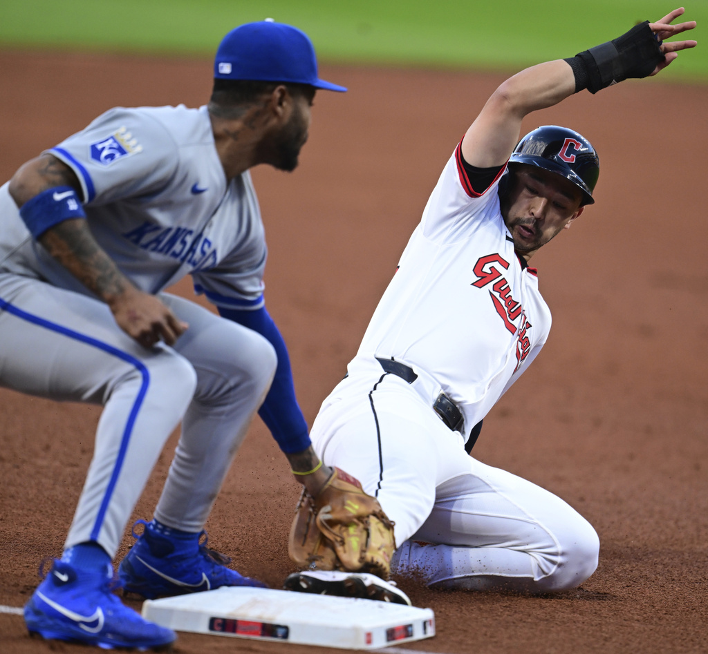 Kansas City Royals third base Maikel Garcia, left, tags out Cleveland Guardians' Steven Kwan at third base on a steal attempt during the first inning of a baseball game, Wednesday, Sept. 10, 2025, in Cleveland. (AP Photo/David Dermer)