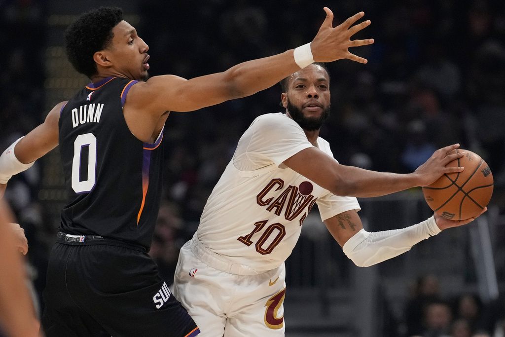 Cleveland Cavaliers guard Darius Garland (10) passes around Phoenix Suns forward Ryan Dunn (0) in the first half of an NBA basketball game Wednesday, Dec. 31, 2025, in Cleveland. (AP Photo/Sue Ogrocki)