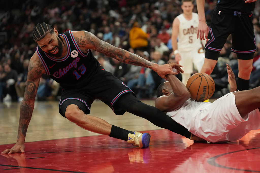Chicago Bulls center Nick Richards, left, and Cleveland Cavaliers center Evan Mobley, front right, fall on the court during the second half of an NBA basketball game Thursday, March 19, 2026, in Chicago. (AP Photo/Erin Hooley)