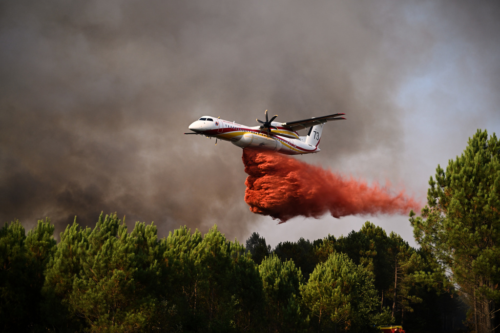 A De Havilland Canada Dash 8-400 releases fire retardant as it flies over a forest near Blagon, during wildfires in southwestern France, Wednesday, July 29, 2026. (AP Photo/Emma Da Silva)