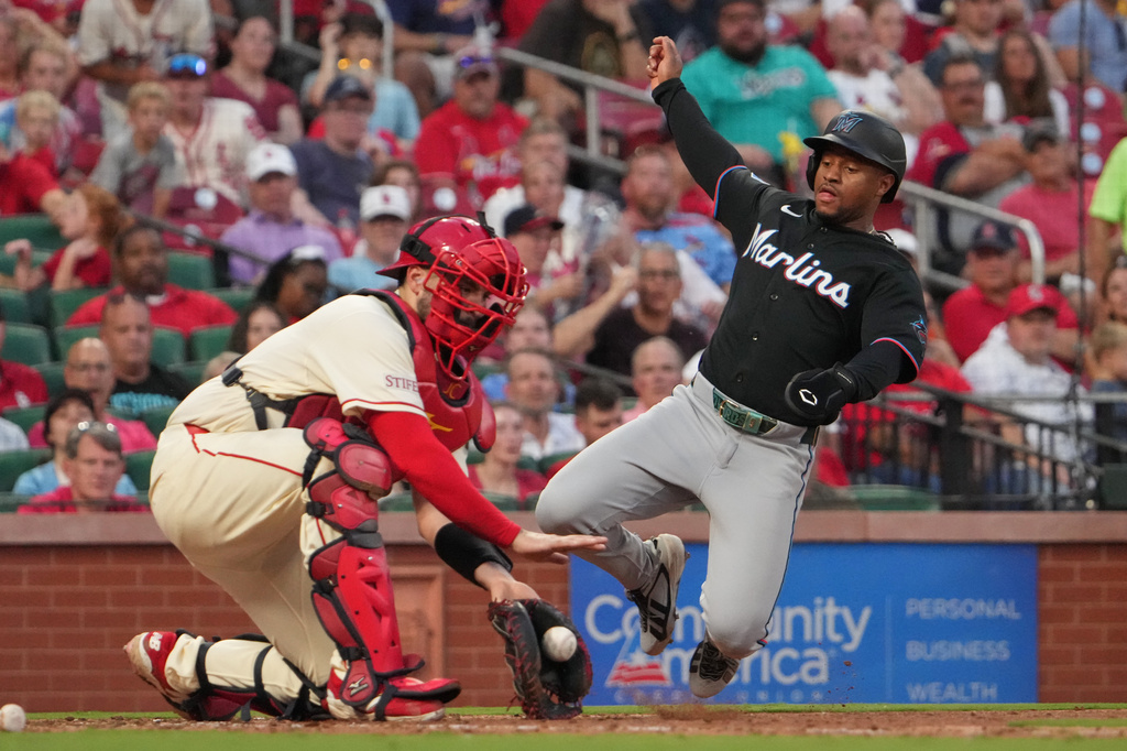 Miami Marlins' Xavier Edwards, right, scores past St. Louis Cardinals catcher Jimmy Crooks during the seventh inning of a baseball game Saturday, June 27, 2026, in St. Louis. (AP Photo/Jeff Roberson)