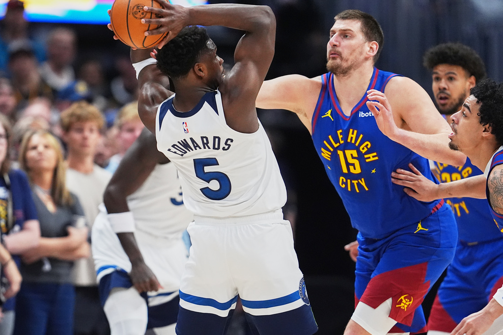 Minnesota Timberwolves guard Anthony Edwards, left, looks to pass the ball as Denver Nuggets center Nikola Jokić defends in the first half of an NBA basketball game, Sunday, March 1, 2026, in Denver. (AP Photo/David Zalubowski)
