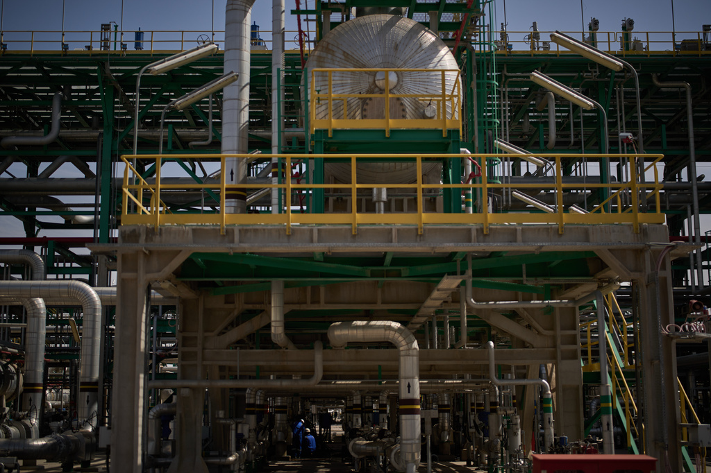 Men work on the maintenance of a pipe at a degassing station in Zubair oil field, whose operations have being reduced due to the Mideast war triggered by the U.S. and Israeli attacks on Iran, near Basra, Iraq, Saturday, March 28, 2026. (AP Photo/Leo Correa)