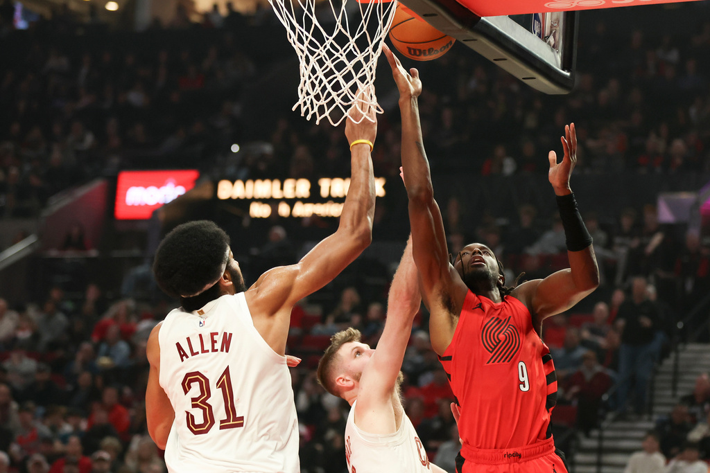 Portland Trail Blazers forward Jerami Grant, right, drives to the basket beside Cleveland Cavaliers forward Dean Wade, center, and center Jarrett Allen, right, during the first half of an NBA basketball game, Sunday, Feb. 1, 2026, in Portland, Ore. (AP Photo/Amanda Loman)
