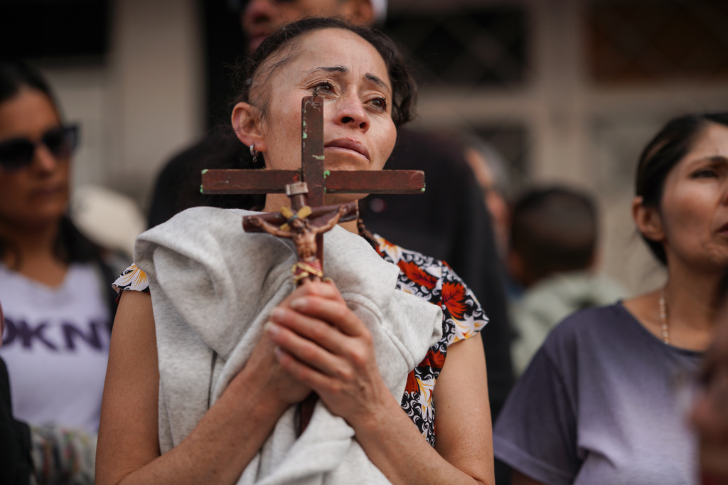 A devotee holds a cross during a Good Friday procession in the Ciudad Bolivar neighborhood of Bogota, Colombia, Friday, April 3, 2026. (AP Photo/Ivan Valencia)