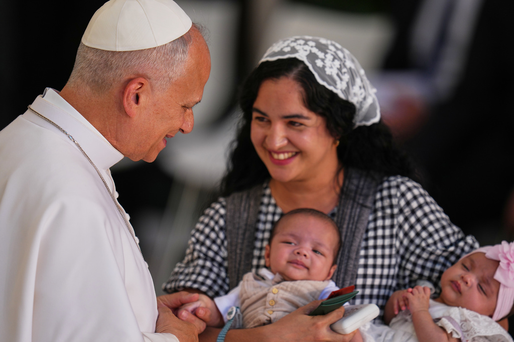 A mother and her two children are greeted by Pope Leo XIV at CEDIA 24 Horas, a comprehensive support center for homeless people, in Madrid, Spain, Saturday, June 6, 2026, on the first day of his seven-day apostolic visit to mainland Spain and the Canary Islands. (AP Photo/Manu Fernandez)