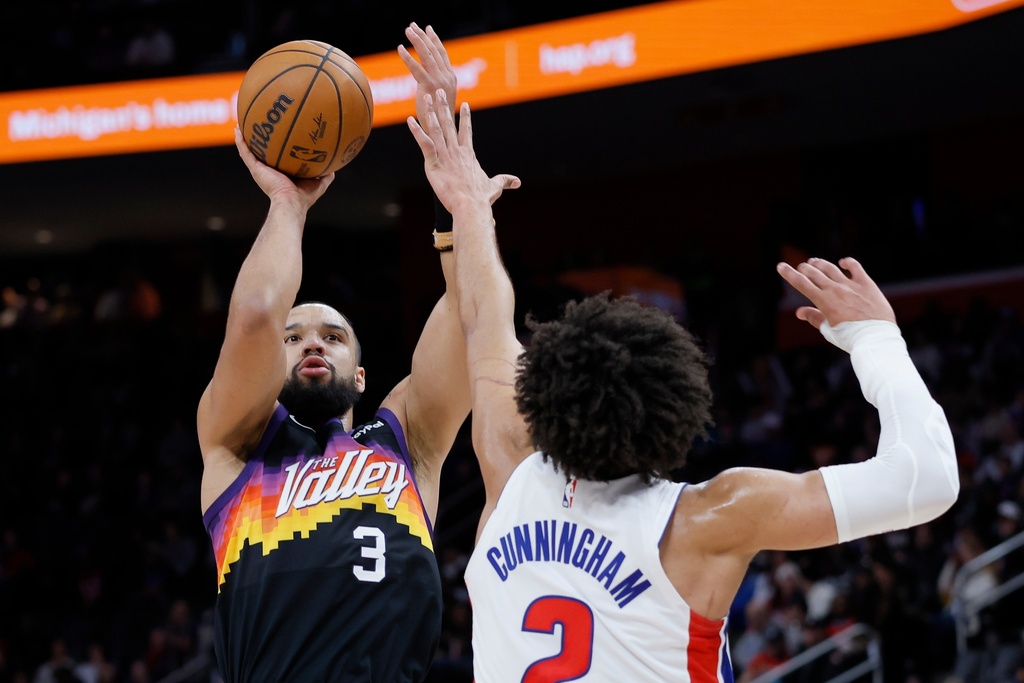 Phoenix Suns forward Dillon Brooks (3) takes a shot against Detroit Pistons guard Cade Cunningham (2) during the first half of an NBA basketball game, Thursday, Jan. 15, 2026, in Detroit. (AP Photo/Duane Burleson)