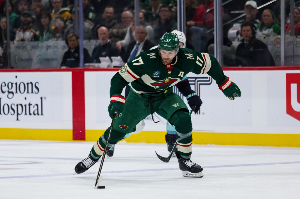 Minnesota Wild's Marcus Foligno (17) controls the puck against the Seattle Kraken during the third period of an NHL hockey game Tuesday, April 7, 2026, in St. Paul, Minn. (AP Photo/Lily Dozier)