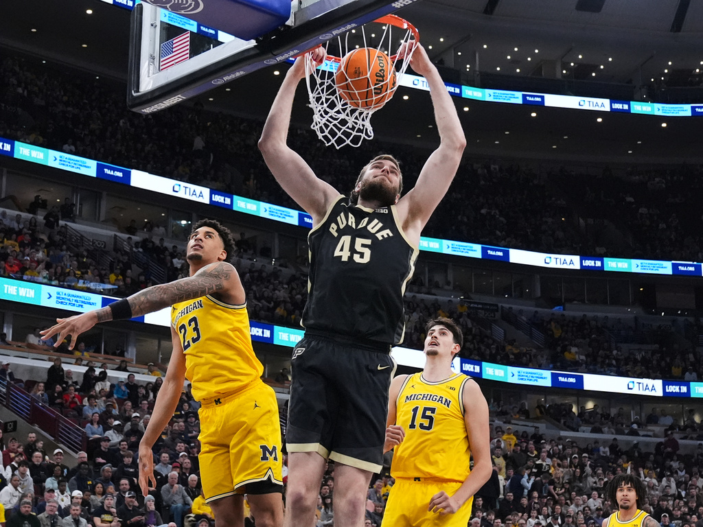 Purdue center Oscar Cluff (45) dunks past Michigan forward Yaxel Lendeborg (23) during the first half of an NCAA college basketball game in the championship of the Big 10 Conference tournament, Sunday, March 15, 2026, in Chicago. (AP Photo/Nam Y. Huh)