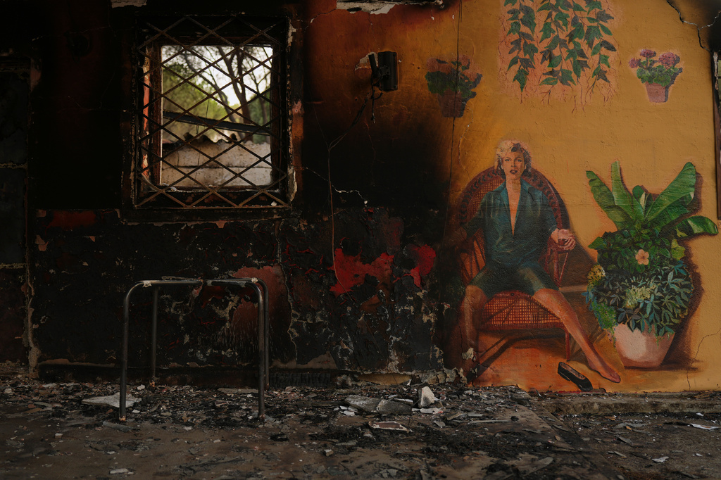 A campsite's bungalows are charred after it was ravaged by a wildfire in Pelayos de la Presa, Madrid province, Spain, Monday, July 27, 2026. (AP Photo/Manu Fernandez)