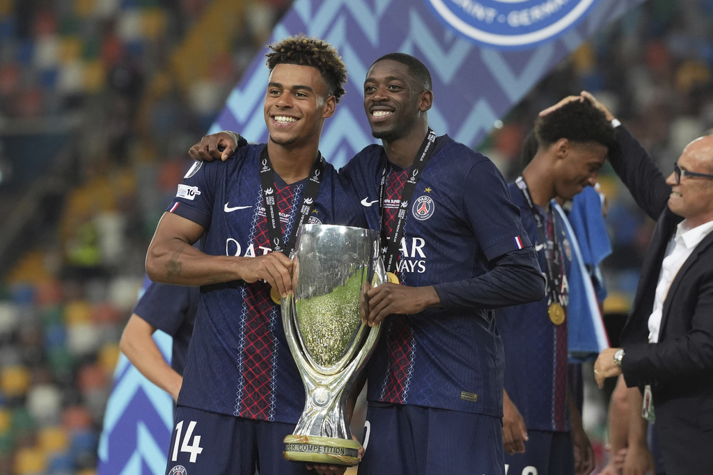 PSG's Desire Doue, left, Paris's Ousmane Dembele pose with the trophy after the UEFA Super Cup soccer match between Paris Saint-Germain and Tottenham Hotspur in Udine, Italy, Wednesday, Aug. 13, 2025. (Massimo Paolone/LaPresse via AP)