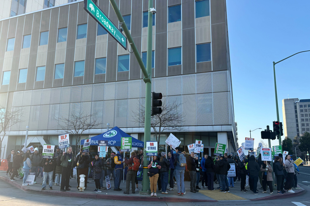 Kaiser Permanente nurses and health workers represented by the United Nurses Associations of California/Union of Health Care Professionals picket outside Kaiser's Oakland Medical Center on the first day of an open-ended strike Monday, Jan. 26, 2026. (Jessica Flores/San Francisco Chronicle via AP)