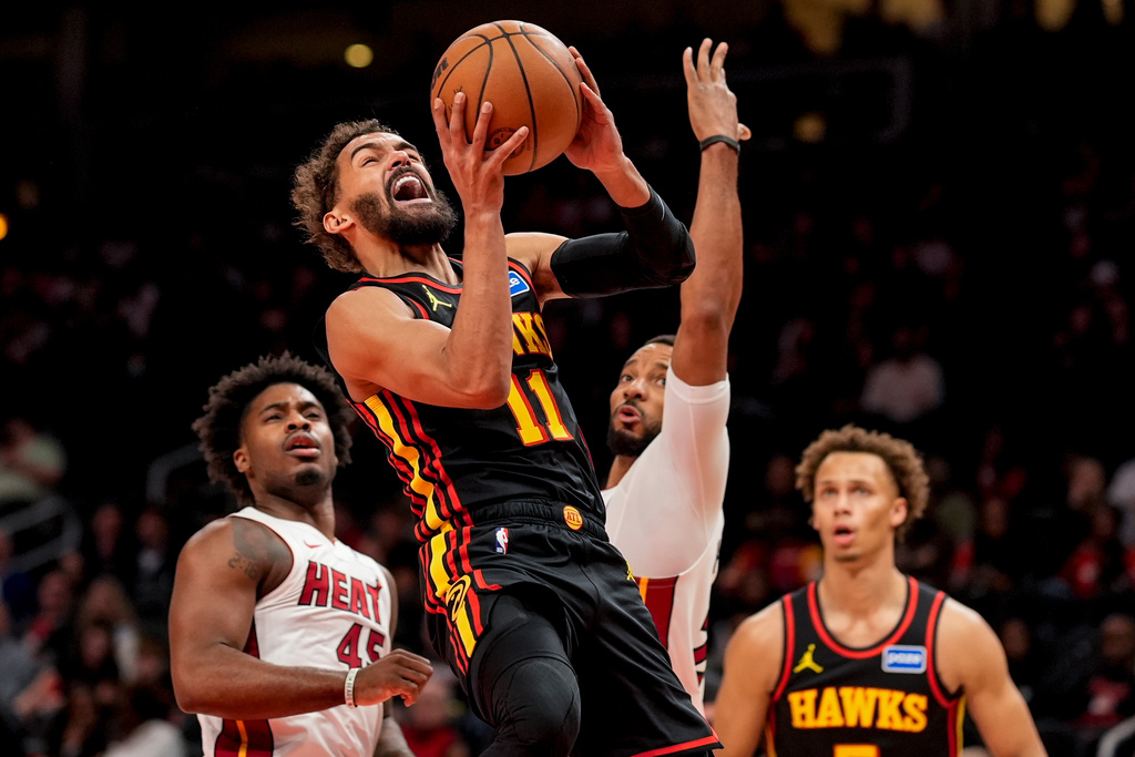 Atlanta Hawks guard Trae Young (11) shoots past Miami Heat guard Davion Mitchell (45) during the first half of an NBA basketball game, Friday, Dec. 26, 2025, in Atlanta. (AP Photo/Mike Stewart)