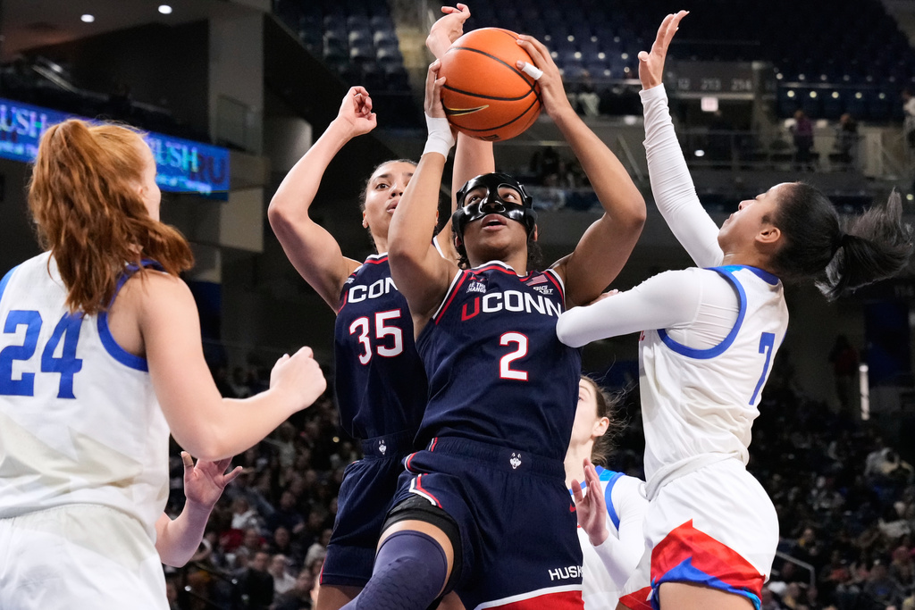 UConn guard KK Arnold (2) rebounds a ball against DePaul guard Devin Hagemann, right, during the first half of an NCAA college basketball game in Chicago, Wednesday, Feb. 4, 2026. (AP Photo/Nam Y. Huh)