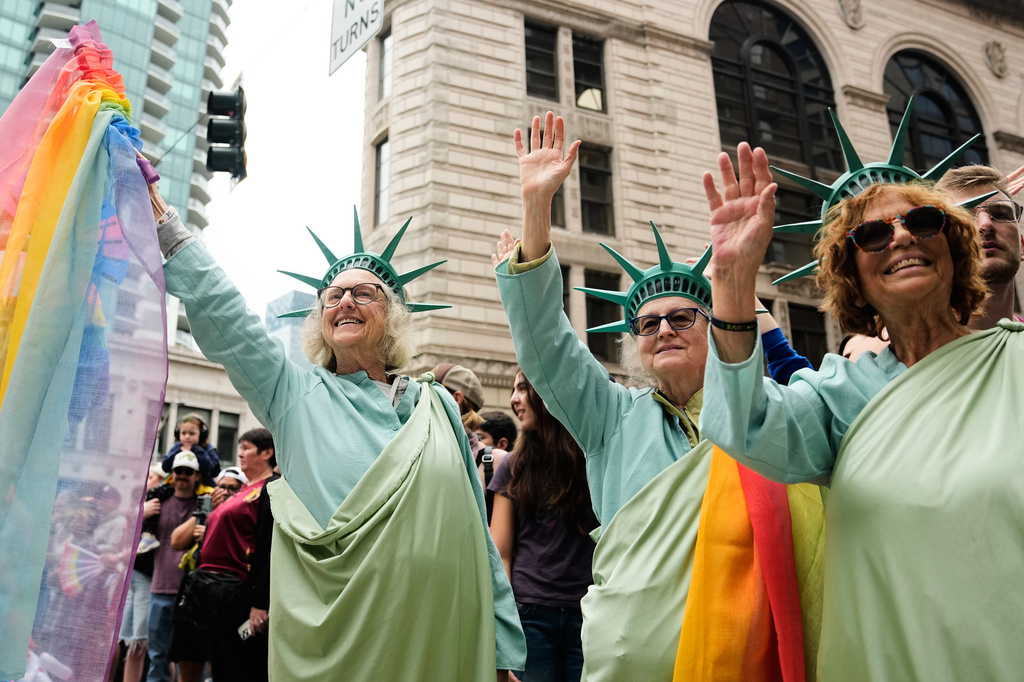 From left, Parker Lindner, Ariel Rathbun and Susan Partnow with the Lady Liberty Project wave at parade participants during the Seattle Pride Parade, Sunday, June 28, 2026, in Seattle. (AP Photo/Lindsey Wasson)