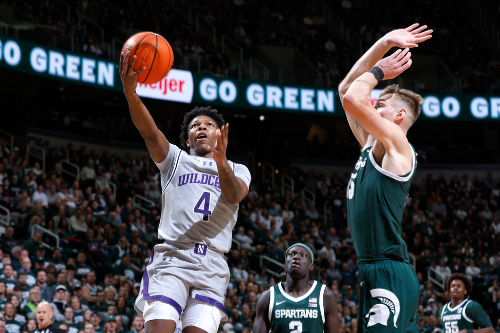 Northwestern guard Jayden Reid (4) shoots against Michigan State center Carson Cooper, front right, during the first half of an NCAA college basketball game, Thursday, Jan. 8, 2026, in East Lansing, Mich. (AP Photo/Al Goldis)