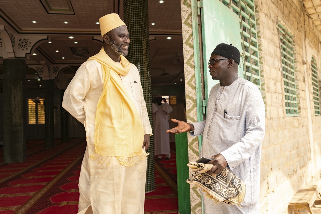 Imam Ibrahima Diane, left, advocate for an end to gender-based violence and practices like female genital mutilation, discusses with El Hadj Malick, coordinator of the "École des Maris" program at the Great Mosque of Nietty Mbar in Thiaroye, a suburb of Dakar, Senegal, Friday, July 4, 2025.(AP Photo/Sylvain Cherkaoui)