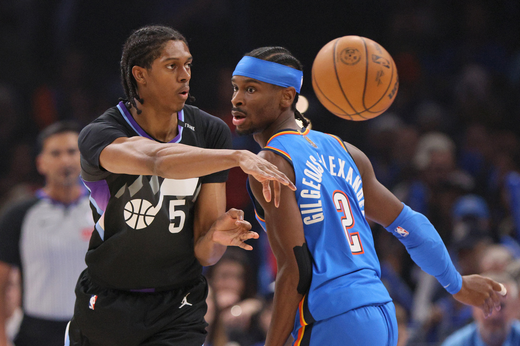 Utah Jazz forward Cody Williams (5) passes the ball away from Oklahoma City Thunder guard Shai Gilgeous-Alexander (2) during the first half of an NBA basketball game Sunday, April 5, 2026, in Oklahoma City. (AP Photo/Nate Billings)