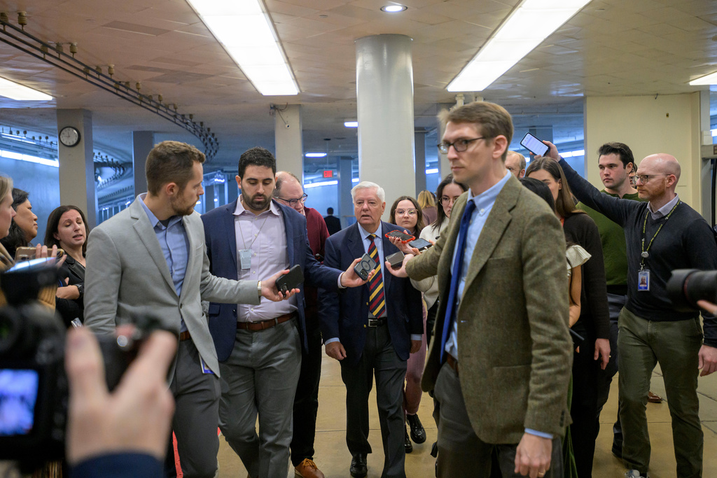 Sen. Lindsey Graham, R-S.C., center, talks with reporters in the Senate subway during a vote at the Capitol, Tuesday, Jan. 6, 2026, in Washington. (AP Photo/Rod Lamkey, Jr.)