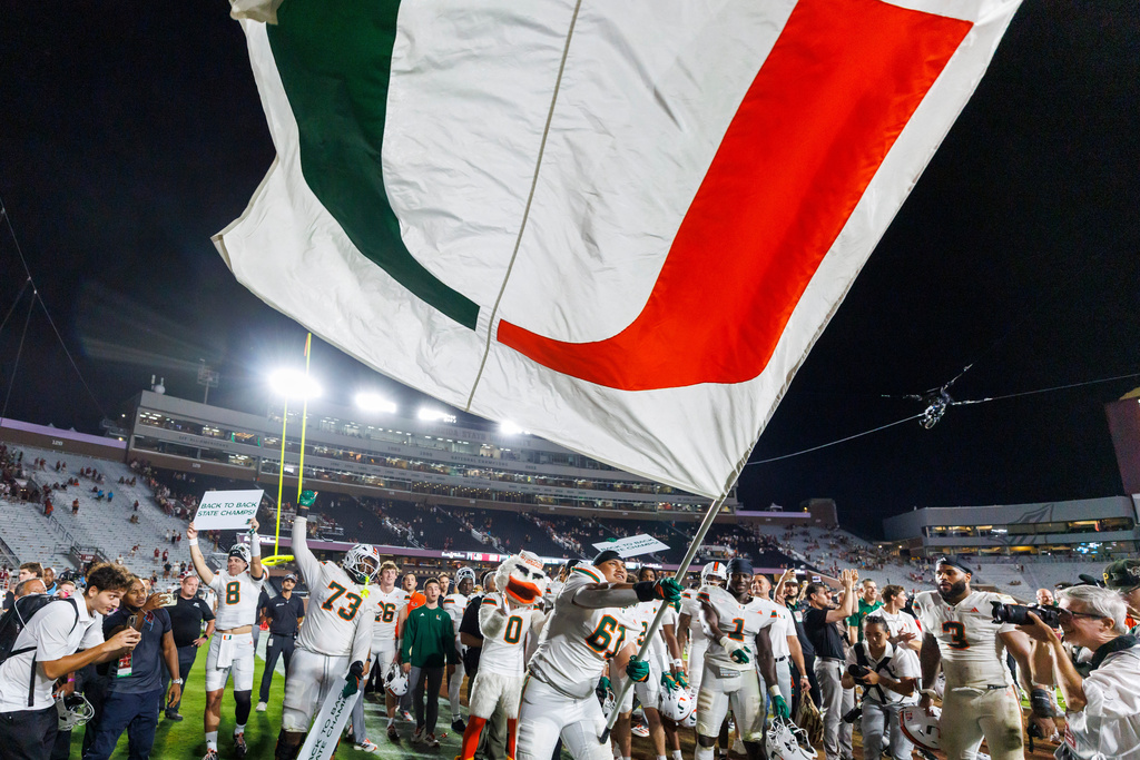 Miami offensive lineman Francis Mauigoa (61) waves the team flag after defating Florida State in a NCAA college football game, Saturday, Oct. 4, 2025, in Tallahassee, Fla. (AP Photo/Colin Hackley)