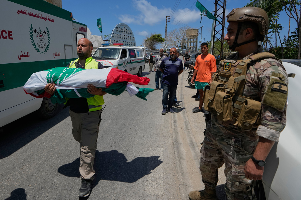 A paramedic volunteer carries a body, one of the six the family members who were killed on Wednesday when their car was struck in an Israeli airstrike on a highway as they fled their village, during a funeral procession in the southern port city of Tyre, Lebanon, Friday, May 29, 2026. (AP Photo/Mohammed Zaatari)