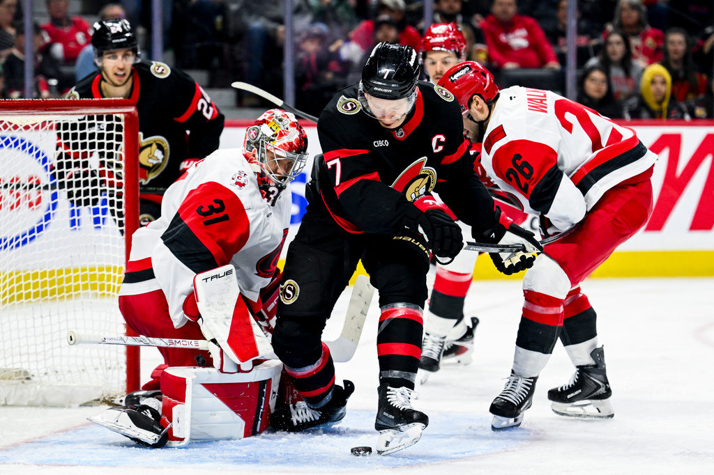 Ottawa Senators' Brady Tkachuk (7) tries to the play the puck off his skate in front of Carolina Hurricanes' goaltender Frederik Andersen (31) during the second period of an NHL hockey game in Ottawa, Ontario, on Sunday, April 5, 2026. (Spencer Colby/The Canadian Press via AP)