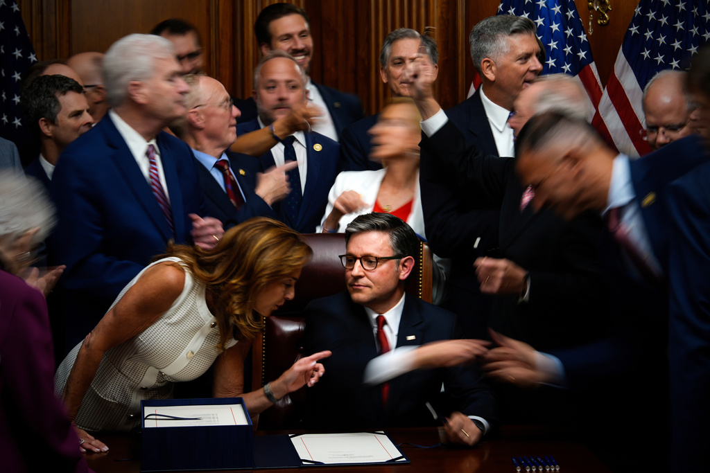 FILE - Republican members of Congress gather round to shake hands with Speaker of the House Mike Johnson, R-La., center bottom, after he signed President Donald Trump's signature bill of tax breaks and spending cuts, at the Capitol in Washington, July 3, 2025. (AP Photo/Julia Demaree Nikhinson, File)