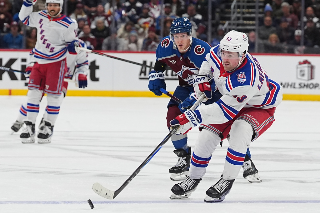 New York Rangers left wing Alexis LafreniËre, front, passes the puck as Colorado Avalanche center Parker Kelly defends in the second period of an NHL hockey game Thursday, Nov. 20, 2025, in Denver. (AP Photo/David Zalubowski)