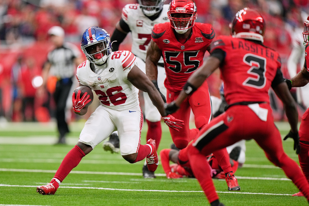 New York Giants running back Devin Singletary (26) breaks away from Houston Texans defenders to score the winning touchdown in overtime of an NFL football game in Houston, Sunday, Oct. 25, 2026. (AP Photo/Gerald Herbert)