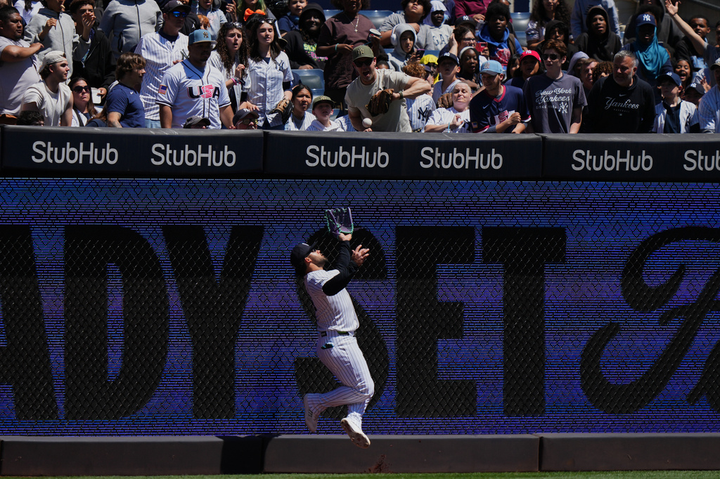 New York Yankees' Jasson Domínguez is injured while catching a ball hit by Texas Rangers' Brandon Nimmo for an out during the first inning of a baseball game Thursday, May 7, 2026, in New York. (AP Photo/Frank Franklin II)