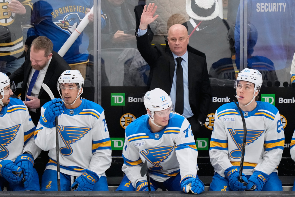 St. Louis Blues head coach Jim Montgomery, top right, formerly head coach of the Boston Bruins, acknowledges the fans' applause during the first period of an NHL hockey game against the Bruins, Thursday, Dec. 4, 2025, in Boston. (AP Photo/Charles Krupa)