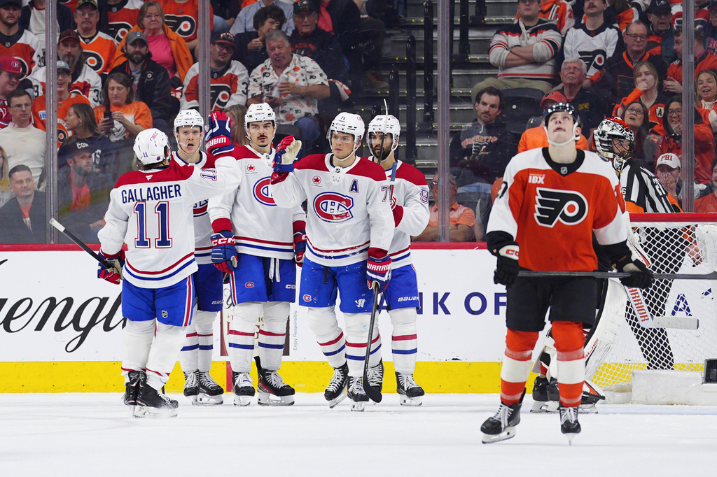 Montréal Canadiens' Jake Evans, center, high fives Brendan Gallagher (11) after Evans scored during the second period of an NHL hockey game against the Philadelphia Flyers, Tuesday, April 14, 2026, in Philadelphia. (AP Photo/Derik Hamilton)
