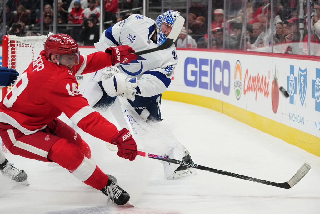 Tampa Bay Lightning goaltender Andrei Vasilevskiy, right, clears the puck against Detroit Red Wings center Andrew Copp during the first period of an NHL hockey game Friday, Nov. 28, 2025, in Detroit. (AP Photo/Ryan Sun)