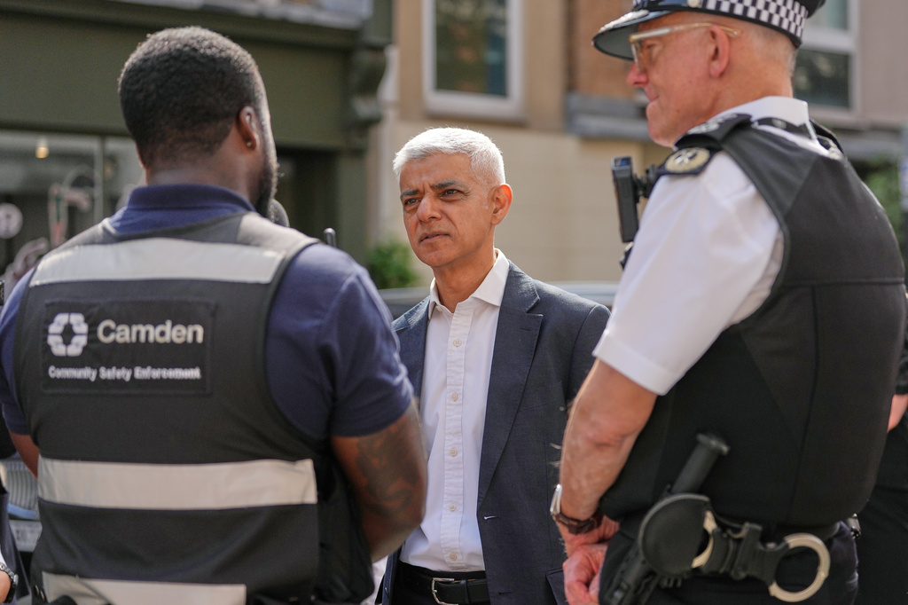 London Mayor Sadiq Khan, centre, and Mark Rowley, Commissioner of Police of the Metropolis, right, speak to staff, during a walkabout through the borough of Camden in London, Thursday, July 23, 2026. (AP Photo/Kirsty Wigglesworth)
