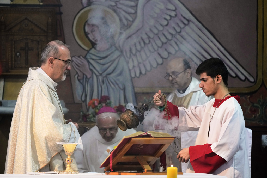 Cardinal Pierbattista Pizzaballa, the Latin Patriarch of Jerusalem, left, leads a Christmas Eve Mass at the Holy Family Catholic Church in Gaza City, Sunday, Dec. 21, 2025. (AP Photo/Jehad Alshrafi)