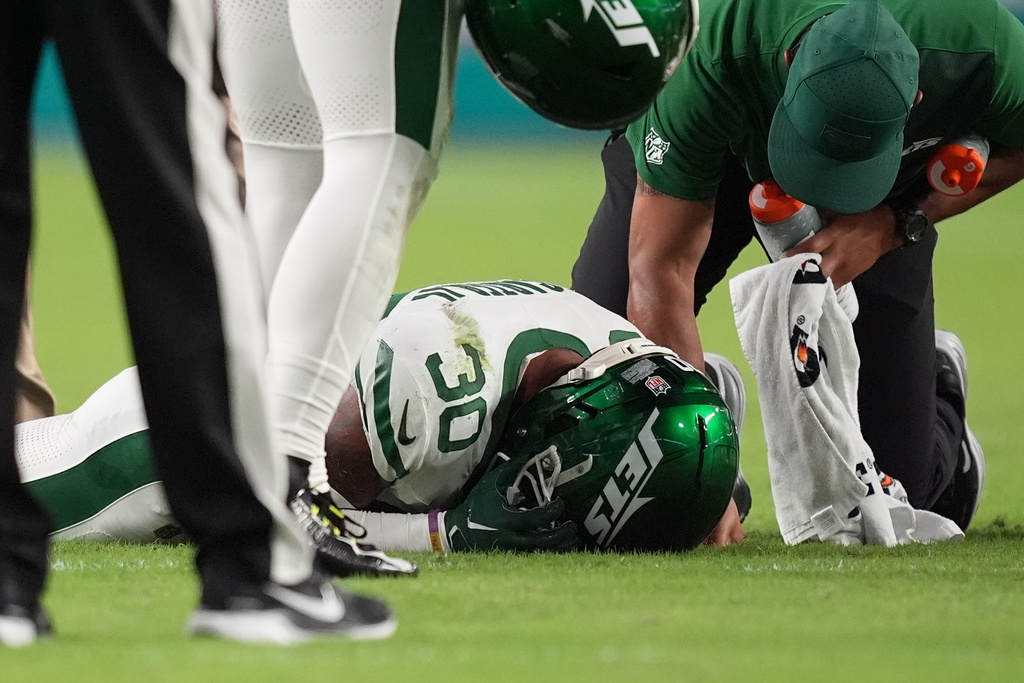 New York Jets cornerback Michael Carter II (30) is assisted by team staff after suffering an unknown injury in the first half of an NFL football game against the Miami Dolphins, Monday, Sept. 29, 2025, in Miami Gardens, Fla. (AP Photo/Rebecca Blackwell)