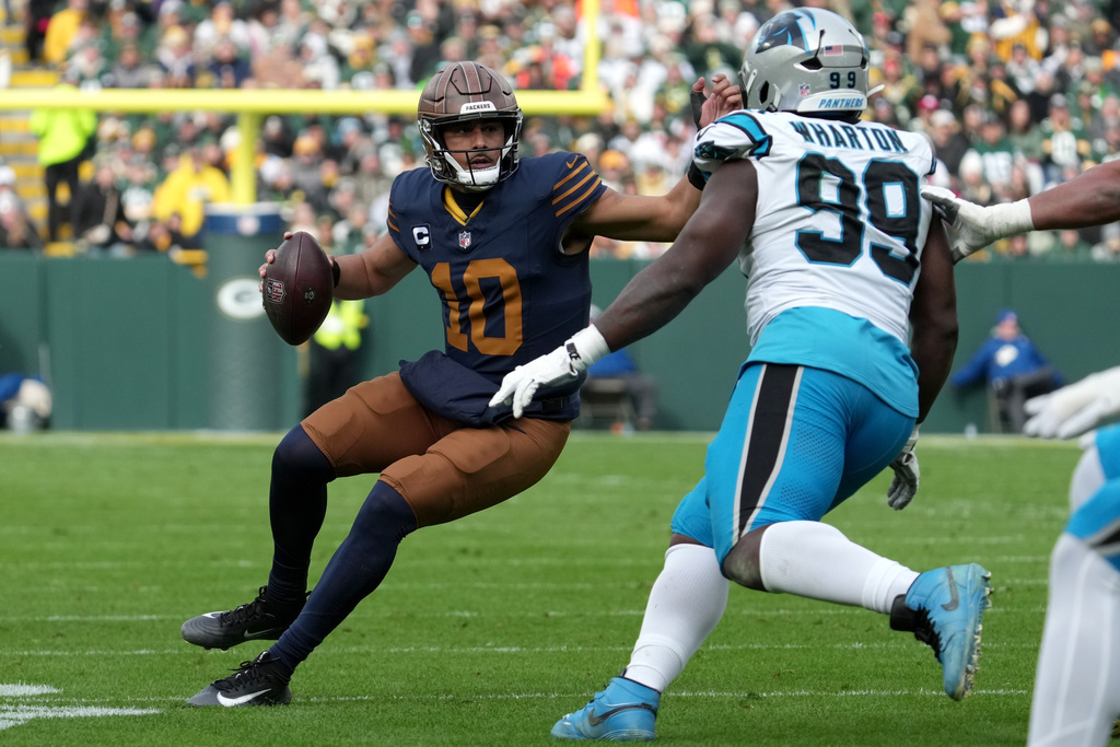 Green Bay Packers quarterback Jordan Love (10) runs against Carolina Panthers defensive tackle Tershawn Wharton (99) during the first half of an NFL football game Sunday, Nov. 2, 2025, in Green Bay, Wis. (AP Photo/Morry Gash)