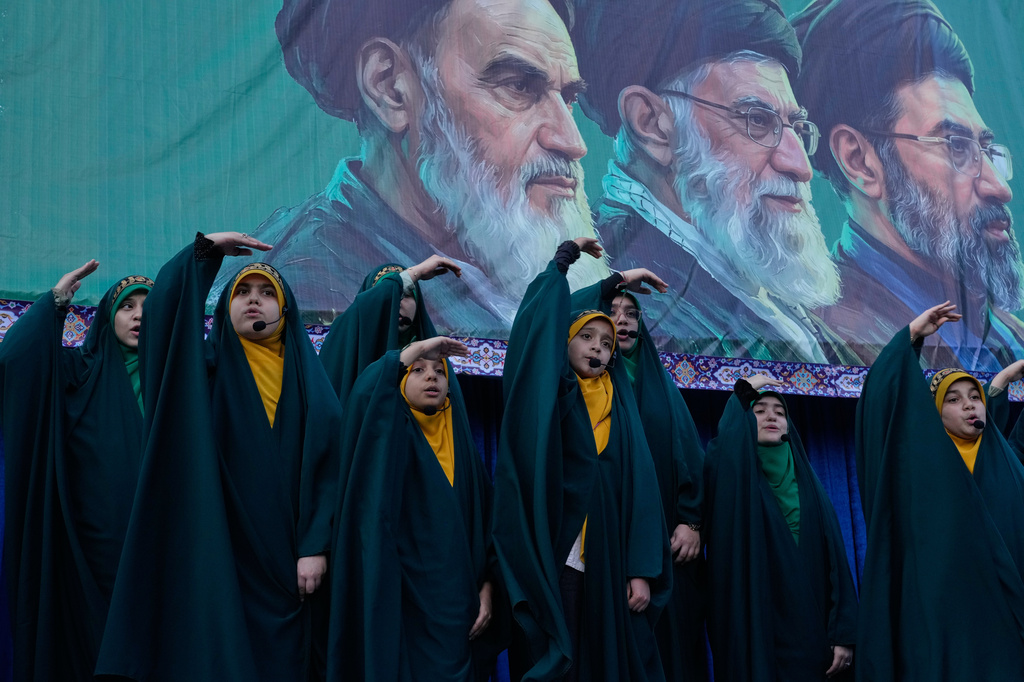 Girls sing a song as they show the movement of missiles with their hands next to the portraits of the late Iranian revolutionary founder Ayatollah Khomeini, left, late Supreme Leader Ayatollah Ali Khamenei, center, and Supreme Leader Ayatollah Mojtaba Khamenei, in a state-organised rally celebrating the birthday of Imam Reza, the 8th Shiite Muslims' Imam, and supporting the supreme leader, in Tehran, Iran, Wednesday, April 29, 2026. (AP Photo/Vahid Salemi)