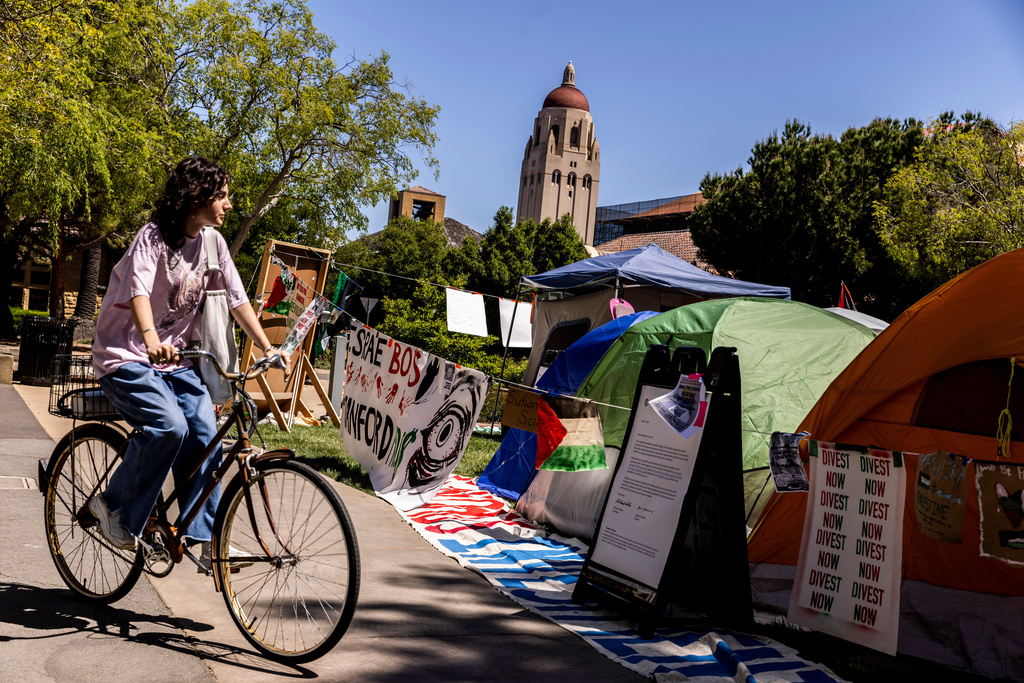 FILE - A bicyclist cycles past a tent encampment in White Plaza at Stanford University in Stanford, Calif., in support of Palestinians, April 30, 2024. (Stephen Lam/San Francisco Chronicle via AP, File)
