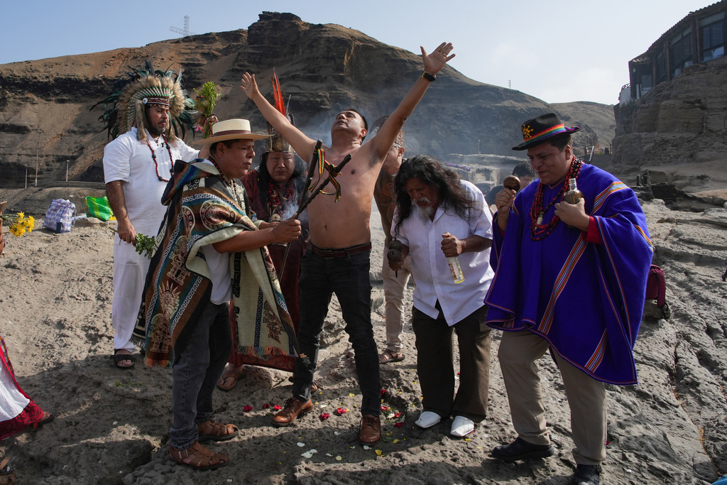 Shamans perform a personalized blessing for a man during their annual ritual to predict political and social issues for the new year, on the coast of Lima, Peru, Monday, Dec. 29, 2025. (AP Photo/Guadalupe Pardo)