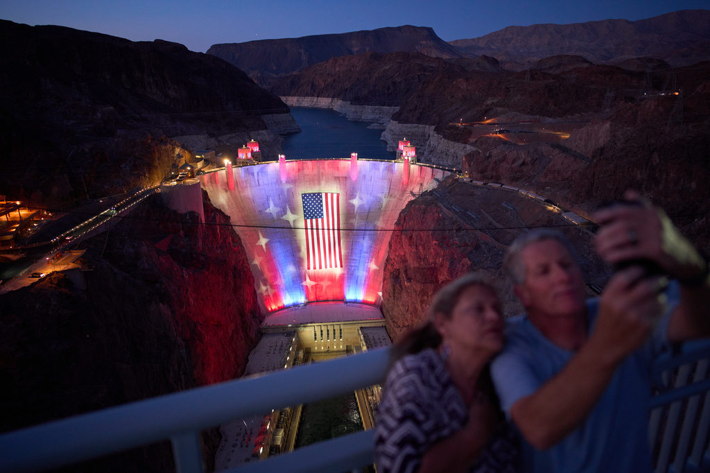 A light show illuminates a U.S. flag on the Hoover Dam at the Lake Mead National Recreation Area Tuesday, June 30, 2026, near Boulder City, Nevada. (AP Photo/John Locher)